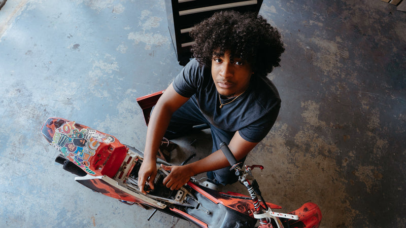 Person working on a skateboard in an indoor setting
