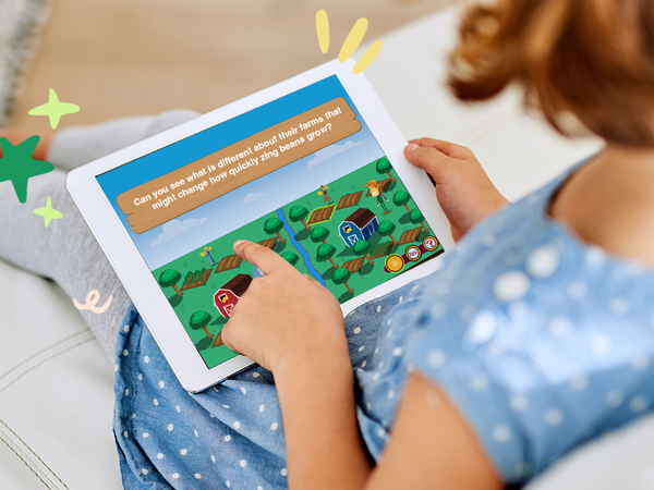 A child is seated on a couch using a tablet computer to engage in an educational activity designed to teach logic and letter recognition. Time4Learning preschool